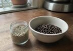 Raw green coffee beans in a jar next to a bowl of roasted coffee beans, illustrating green coffee for weight loss