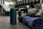 An energy drink can on a gym floor next to a kettlebell, gym bag and towel